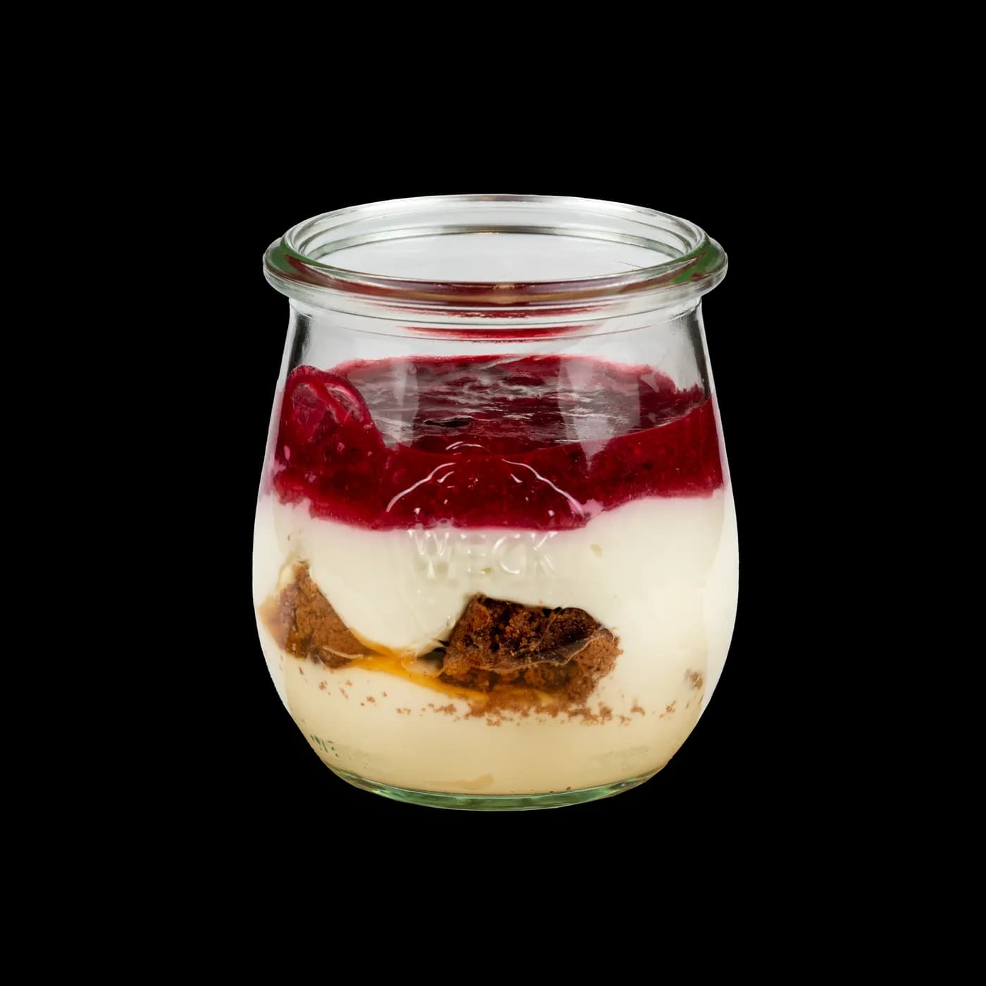 Geschichtete Quarkspeise mit Keksboden und Beerenpürree im Glas